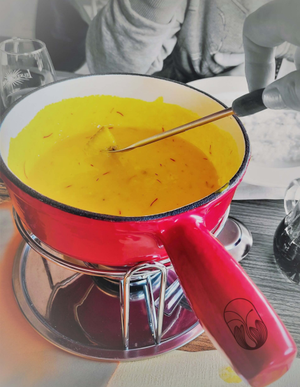 Un caquelon de fondue savoyarde contenant des stigmates de safran, ce qui permet de bénéficier de tous les bienfaits du safran en cuisine